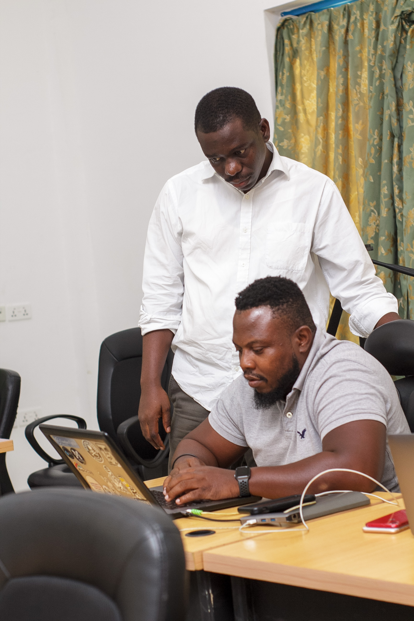 Raphael Amponsah helping a student to code